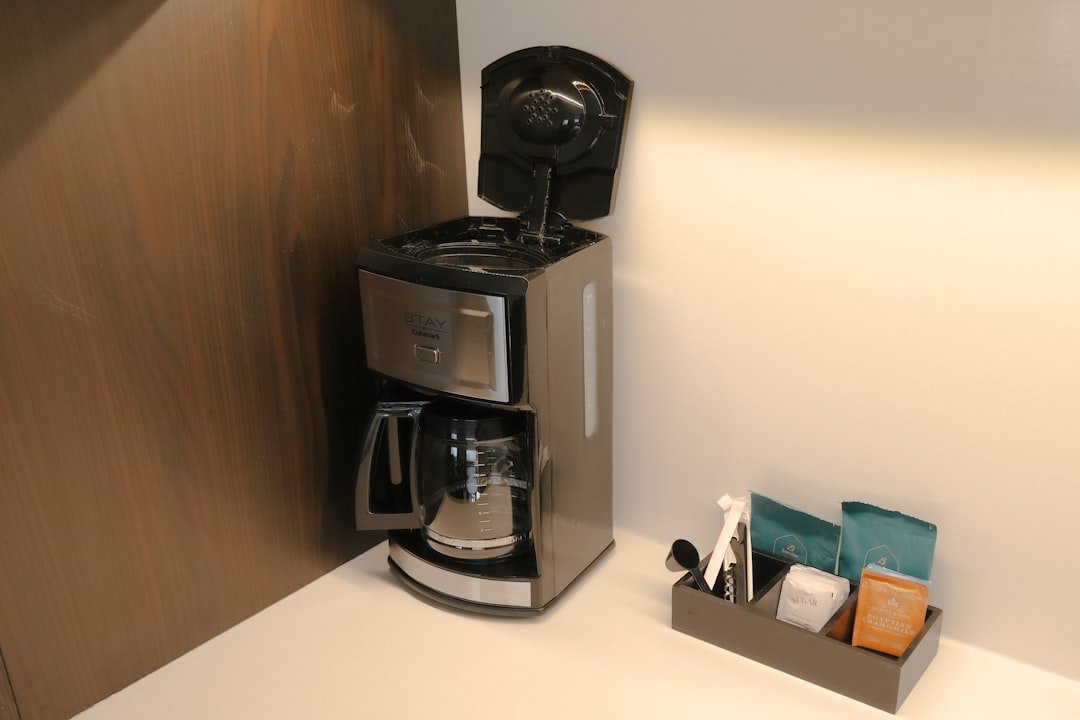 A compact coffee maker and daily supplies arranged in a small kitchen corner.