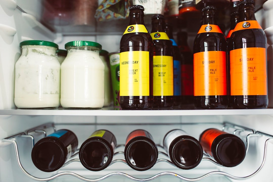 Milk and drink bottles stored upright across a refrigerator door shelf.