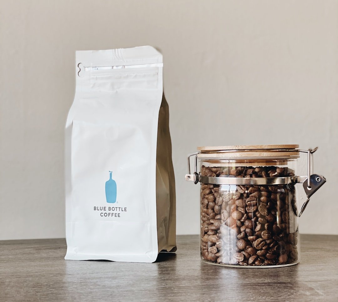 Coffee bag and beans in a jar on a simple counter.