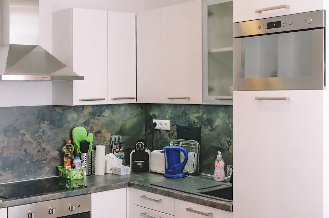 Compact kitchen counter with kettle and small appliances near the stove.