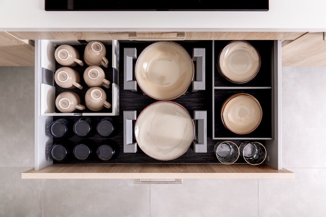 Organized drawer with mugs, bowls, and small drink tools.